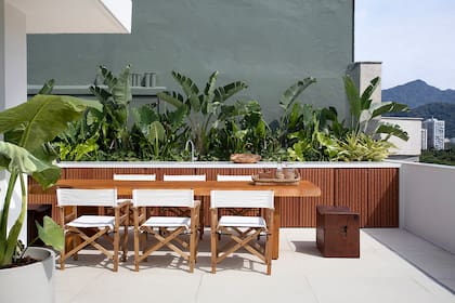 En el lateral, mueble de frente varillado, mesada y bacha, y parrilla a gas. La vegetación hace su parte para cerrar el ambiente.