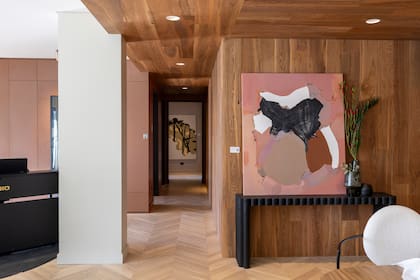 En el living-comedor-cocina integrado: pisos de roble de Eslavonia en formato Chevron, y roble de Eslavonia en paredes y techo de la zona de circulación.