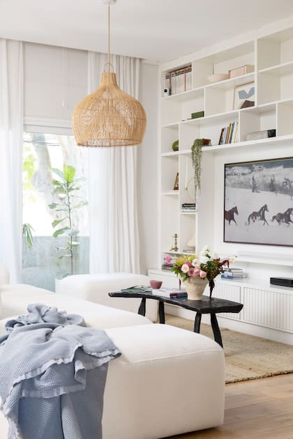 En el living de su PH de Colegiales, Rob Ortiz tiene una alfombra (Seara), sillón de bouclé modular, mesa ratona rústica de madera quemada (ambos, Rob Ortiz estudio) y lámpara de techo (Gramineas Deco)