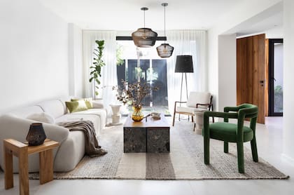 En el living, el estudio MMO Arquitectas eligió lámparas de techo (Lämmin); sofá (Lobo) con manta (Lote Propio); mesa de arrime, ratona y sillón verde (Par en Par); almohadones de pana verde y sillón con cuerpo de madera (Tapicería Carlos Méndez); lámpara de pie (Increa); alfombra (Maki Warmi).