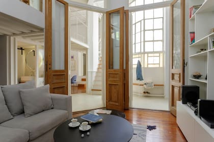 En el living, la biblioteca (Estudio Javier Müller) toma la doble altura con estructura, estantes y cajones de melamina blanca de 15mm. Mesas de centro de hierro negro, una de ellas con tapa de mármol ‘Negro Marquina’ (Lebon House).