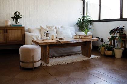 En el living, mueble con esterilla (Carola Mauer), sillón (Debois Concept), puf de terciopelo (Casa Lulu), mesa ratona (Familia Echaide), bandeja y alfombra (todo, Teodolina Deco).