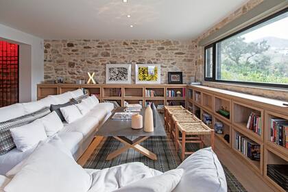En el living, sofá en ‘L’ (Sits), banquetas de mimbre (Pomax) y coffee table con tapa de roble macizo y patas en cruz (Colombus).