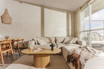 En el living, sofá en L tapizado en pana color arena (Baume). Mesa ratona (Miquela Wood) y alfombra y manta ‘Huacalera’ (Elementos Argentinos).