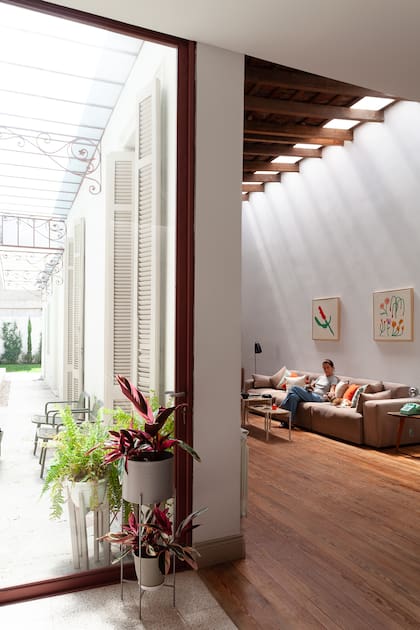 En el living, sofá modular (Club Sillón) y láminas certificadas 'Flora' y 'Rosa' (Pared) enmarcadas