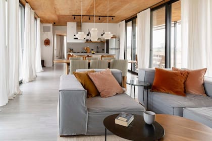 En el living, todo a medida: sofá de tres módulos (Inés Coviello), almohadones con géneros de De Levie y cortinas de gasa de algodón (todo de Maru Bardó).