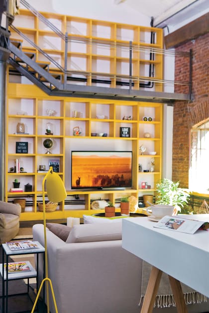 En el loft del diseñador francés Lionel Peralta en La Algodonera vimos una biblioteca pintada de amarillo que tomaba la doble altura con energía