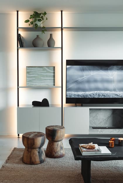 En el mueble (Dash) para la TV (Samsung), objetos deco (Philippa Deco Boutique). Mesa de centro (Ce.Ce Piume) con velas (Bohemia Velas) y cuenco de cerámica (Antes Pella). Taburetes (Vienede).