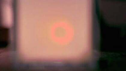 En el otro extremo del tanque con agua y leche, la luz de la misma linterna se ve rojiza.