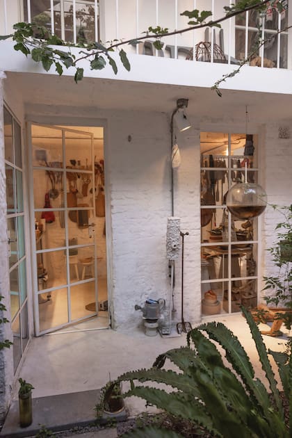 En el patio posterior, que da a la cocina, hay una huerta realizada en cajones sobre caballetes antiguos de hierro y esferas de vidrio suspendidas con plantas acuáticas.