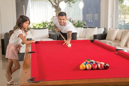 En el quincho hay una mesa de pool que también se transforma en mesa de ping-ping. Aquí vemos a Leandro y su hija en pleno juego.