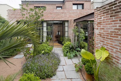 En el recorrido de acceso se observa la concesión de la casa con el jardín mediante una fachada de vidrio.