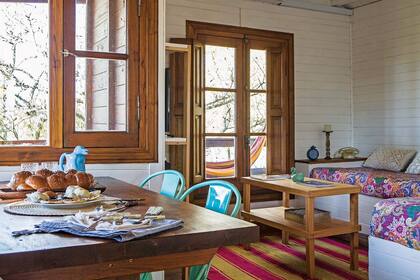 En la mesa, una trenza (Oh! Jalá) acompañada de ricuras de la cocina judía (Cinthia Lecman), pingüino de cerámica (Don Terrenal). Cubiertos de madera patinados (BeChic Market) sobre servilletas color crudo (The Simple Room) y repasador de lienzo (Agustina Cerato).