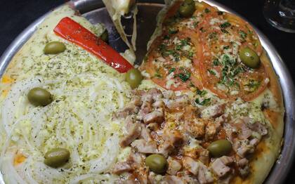 En El Solar de Don Fermín hay pizzas al molde o a la piedra que pueden acompañarse con fainá por porción.
