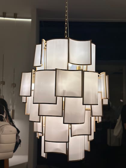 En el stand de Bella Iluminação, las pantallas superpuestas de esta luminaria colgante crea un juego de capas y brillo suave, una pieza icónica que sintetiza la elegancia de la marca.