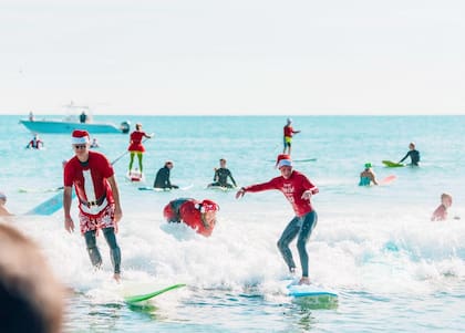 En el Surfing Santas participan familias y personas de todas las edades, que buscan darle un giro distinto a la temporada navideña (Instagram/@surfingsantas)