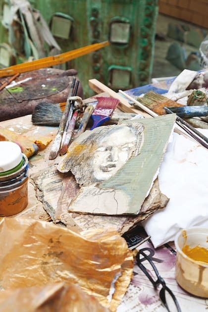 En el taller iluminado por luz natural conviven instalaciones, cuadros, libros y bocetos