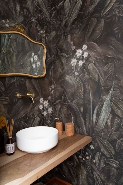 En el toilette, empapelado (Mercedes Costal), espejo antiguo (Feria de Anticuarios de Acassuso), bacha ‘Olivier’ (Barugel) y grifería de pared (GrifosYa).