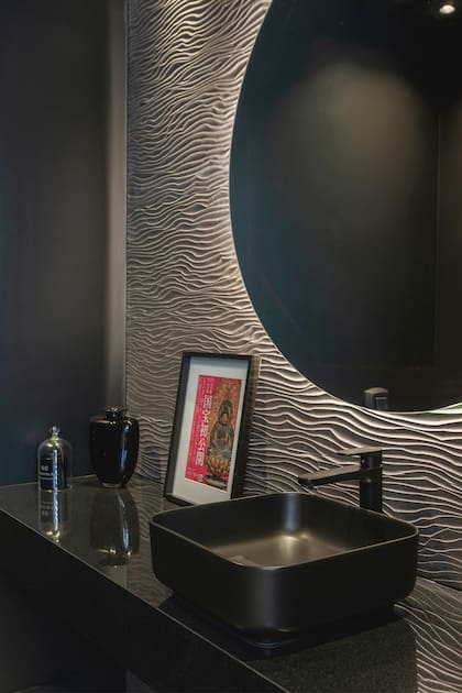 En el toilette, la pared principal está revestida con un panel texturizado, que en una primera impresión parece un papel.