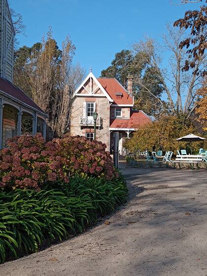 En esta adorable construcción secundaria (de material, y no de madera), hay un café con mesitas adentro y afuera.