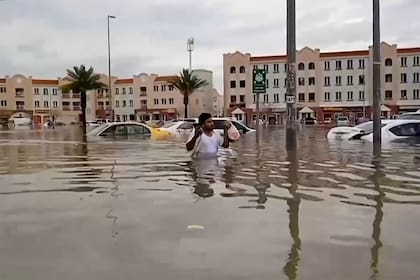 En esta captura de video de AFPTV, un hombre atraviesa una calle inundada en Dubai el 16 de abril de 2024. 