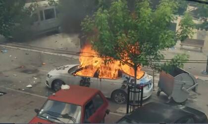 En esta captura de video, se ve un auto incendiado mientras soldados de la KFOR se enfrentan a serbokosovares en la ciudad de Zvecan, norte de Kosovo, lunes 29 de mayo de 2023.
