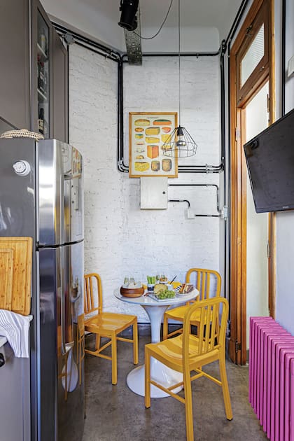 En esta cocina mínima de estilo industrial, el color es la decoración: objetos funcionales en tonos vibrantes se vuelven protagonistas del espacio.