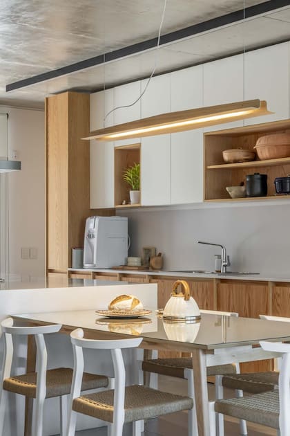 En esta cocina proyectada por el estudio Más Conceptual, lámpara colgante de Boutique de Luz en la mesa de comedor diario junto a la isla.