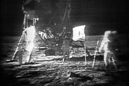 En esta foto de archivo del 20 de julio de 1969, el astronauta del Apolo 11, Neil Armstrong, a la derecha, avanza a través de la superficie de la luna dejando huellas. La bandera de los Estados Unidos, plantada en la superficie por los astronautas, se puede ver entre Armstrong y el módulo lunar
