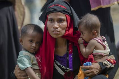 En esta foto de archivo del 22 de octubre de 2017, la mujer musulmana rohingya, Rukaya Begum, que cruzó de Myanmar a Bangladesh, sostiene a su hijo Mahbubur Rehman y a su hija Rehana Bibi, después de que el gobierno los trasladó a las áreas de campamento de refugiados cerca de Kutupalong, Bangladesh