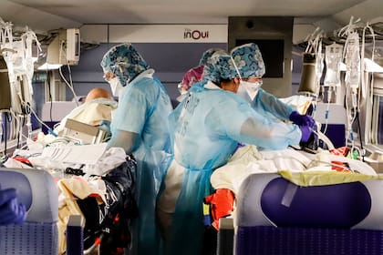 En esta foto de archivo tomada el 1 de abril de 2020, el personal médico instala pacientes infectados con coronavirus a bordo de un tren de alta velocidad TGV en la estación de trenes Gare dAusterlitz en París