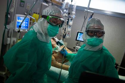 En esta foto de archivo tomada el 16 de abril de 2020 dos trabajadoras sanitarias atienden a un paciente con coronavirus en la Unidad de Cuidados Intensivos del Hospital Povisa de Vigo, noroeste de España