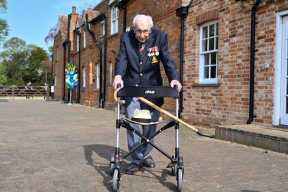 En esta foto de archivo tomada el 16 de abril de 2020, el veterano de la Segunda Guerra Mundial británico, el Capitán Tom Moore, de 99 años, posa con su andador haciendo una vuelta a su jardín en el pueblo de Marston Moretaine, al norte de Londres