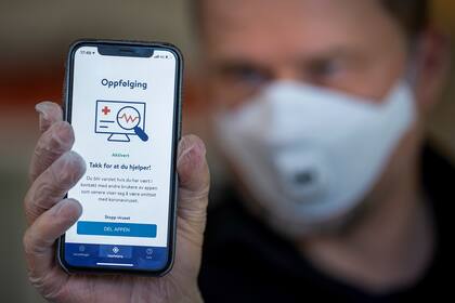 En esta foto de archivo tomada el 17 de abril, un hombre sostiene un teléfono inteligente que muestra una aplicación de rastreo lanzada por el Instituto Nacional de Salud Pública de Noruega para tratar de detener la propagación del nuevo coronavirus