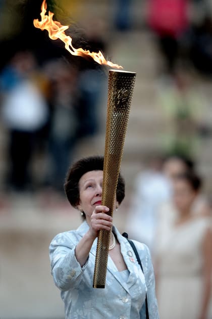 En esta foto de archivo tomada el 17 de mayo de 2012 la princesa Ana de Gran Bretaña sostiene la antorcha con la llama olímpica durante los Juegos Olímpicos.