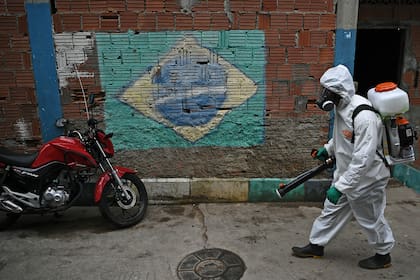 En esta foto de archivo tomada el 18 de abril de 2020, un voluntario desinfecta un área en la favela de Babilonia, en Río de Janeiro, Brasil