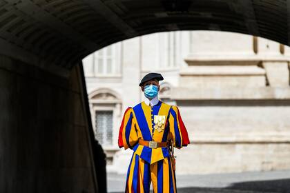 En esta foto de archivo tomada el 18 de mayo de 2020, un guardia suizo con una mascarilla hace guardia junto a la Basílica de San Pedro