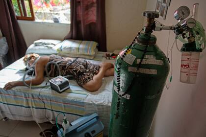 En esta foto de archivo tomada el 2 de febrero de 2021 Dilza Maria Pereira Rodrigues, de 71 años, recibe tratamiento por Covid-19 en su casa luego de 15 días de tratamiento en el hospital de Manaus, Brasil