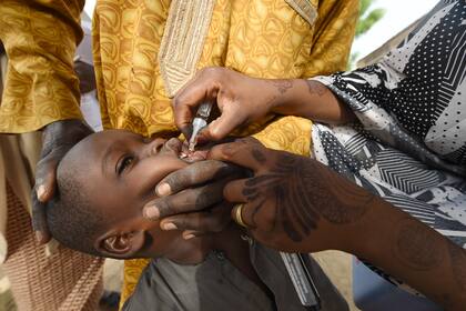 En esta foto de archivo tomada el 22 de abril de 2017, un trabajador de salud administra una vacuna a un niño durante una campaña de vacunación contra la poliomielitis en el noroeste de Nigeria