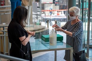 En esta foto de archivo tomada el 25 de mayo de 2020, una empleada de la tienda Simons explica los procedimientos de seguridad de la salud a un cliente, en Montreal, Canadá