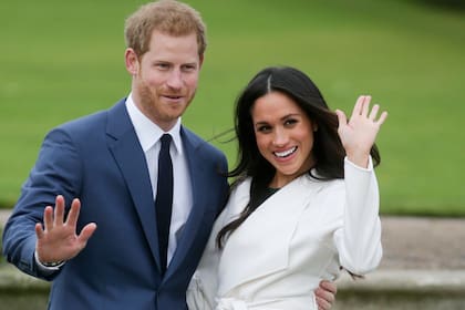 En esta foto de archivo tomada el 27 de noviembre de 2017, el príncipe Harry de Gran Bretaña y su prometida entonces, la actriz estadounidense Meghan Markle, posan para una fotografía en el Sunken Garden del Palacio de Kensington en el oeste de Londres tras el anuncio de su compromiso