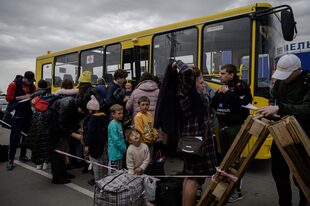En esta foto de archivo tomada el 29 de abril de 2022, familias procedentes de los territorios ocupados por Rusia en la región de Zaporizhzhia llegan en un convoy humanitario a un centro de registro y procesamiento de desplazados internos 