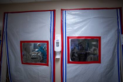 En esta foto de archivo tomada el 3 de enero de 2021, una enfermera con equipo de protección personal atiende a un paciente de Covid-19 dentro de una Unidad de Cuidados Intensivos (UCI) temporal en el Centro Médico Providence Cedars-Sinai Tarzana, en California