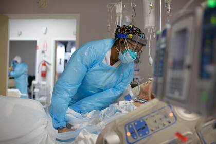 En esta foto de archivo tomada el 4 de diciembre de 2020, la trabajadora de la salud Demetra Ransom consuela a un paciente en la sala Covid-19 del United Memorial Medical Center en Houston, Texas