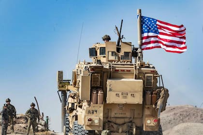 En esta foto de archivo tomada el 6 de octubre de 2019, un soldado estadounidense se sienta encima de un vehículo blindado durante una manifestación de kurdos sirios contra las amenazas turcas