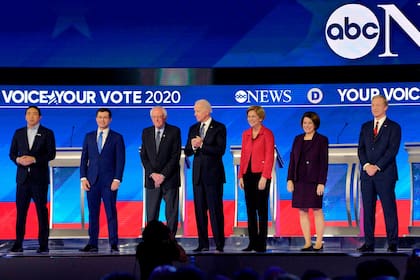 En esta foto de archivo tomada el 7 de febrero, Andrew Yang, Pete Buttigieg, Bernie Sanders, Joe Biden, Elizabeth Warren, Amy Klobuchar y Tom Steyer llegan al escenario para el octavo debate primario demócrata de la temporada de la campaña presidencial de 2020