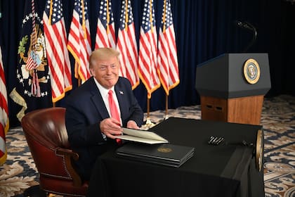 En esta foto de archivo tomada el 8 de agosto de 2020, el presidente de Estados Unidos, Donald Trump, firma órdenes ejecutivas que extienden el alivio económico del coronavirus, durante una conferencia de prensa en Bedminster, Nueva Jersey