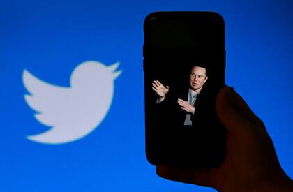 En esta foto de ilustración de archivo tomada el 4 de octubre de 2022, la pantalla de un teléfono muestra una foto de Elon Musk con el logotipo de Twitter de fondo en Washington, DC. 
