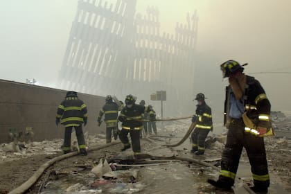 En esta foto del 11 de septiembre de 2001, los bomberos trabajan bajo los parteluces destruidos