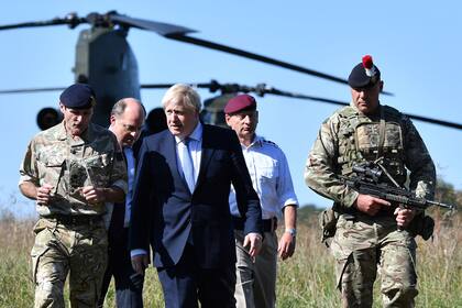 En esta foto del 19 de septiembre de 2019, el primer ministro británico, Boris Johnson llega con el secretario de Defensa británico Ben Wallace para visitar al personal militar en el área de entrenamiento de la llanura de Salisbury, en el suroeste de Inglaterra